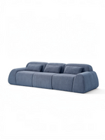 Sofa modulaire bleu TOCO Meubles en tissu contemporain avec trois assises et coussins assortis sur fond blanc