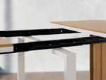 Table à manger extérieure extensible Transformer en chêne clair, cadre blanc – gros plan sur le bois massif, mécanisme coulissant – Meubles TOCO