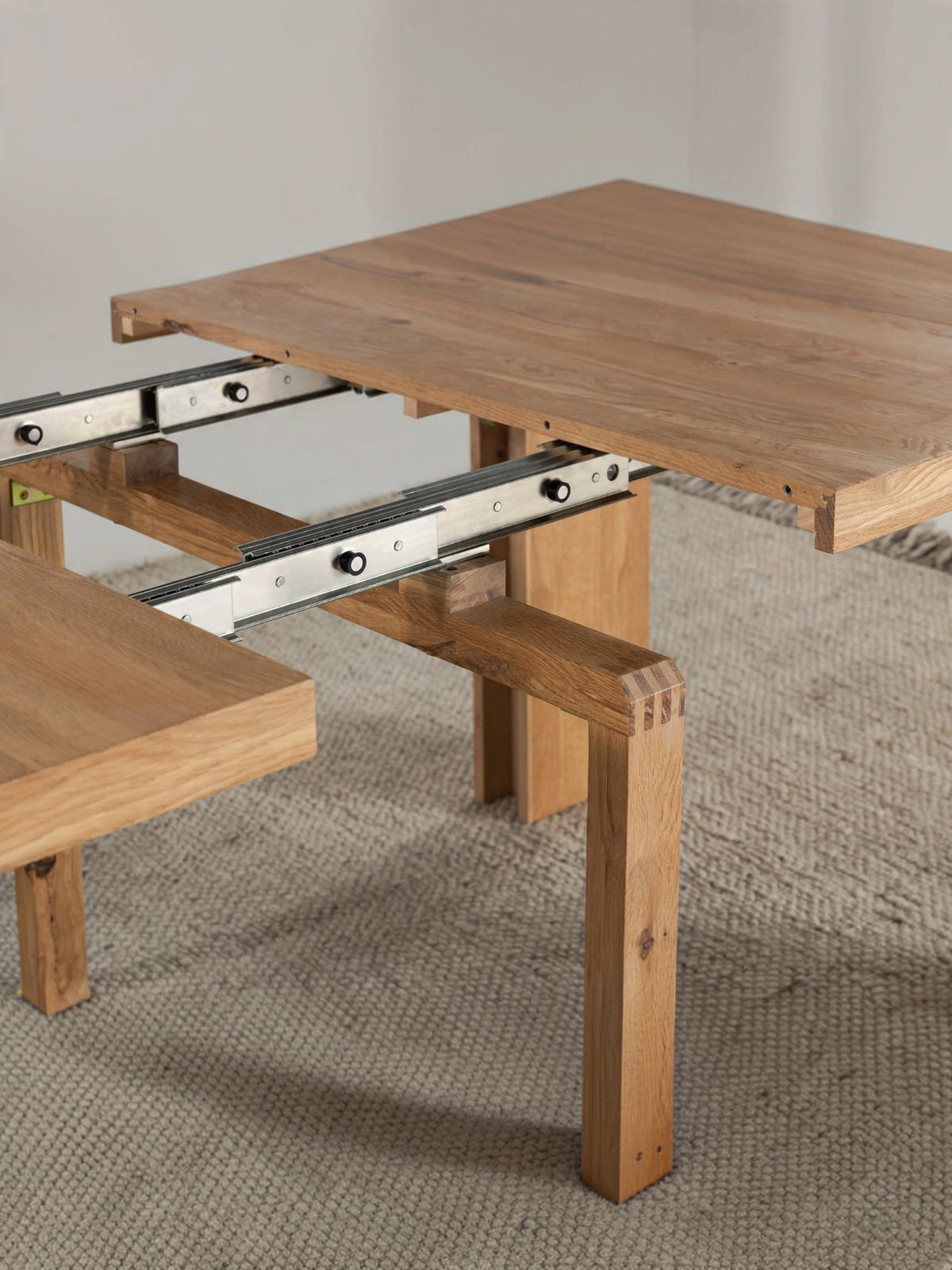 Table à manger extensible Transformer en chêne scandinave – gros plan sur le bois massif, mécanisme coulissant, mise en situation – Meubles TOCO
