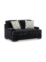 Causeuse Mistral TOCO Meubles en tissu noir texturé avec deux coussins décoratifs à motifs géométriques