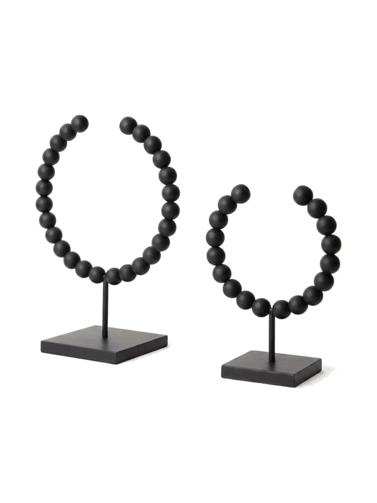 Deux objets décoratifs Tulane TOCO Meubles en forme de sphères brisées avec perles noires mates sur socles carrés.