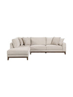 Sofa sectionnel Calvi de TOCO Meubles en tissu chenille beige avec coussins décoratifs et pieds en bois brun foncé.