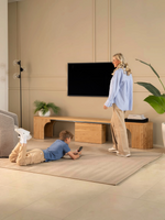 Banc rond extensible TOCO Meubles en bois clair utilisé comme console sous une télévision dans un salon moderne