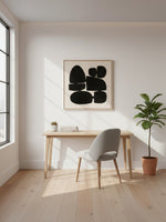 Cadre décoratif Pillars I de TOCO Meubles avec motif abstrait noir sur fond clair dans un bureau moderne et lumineux