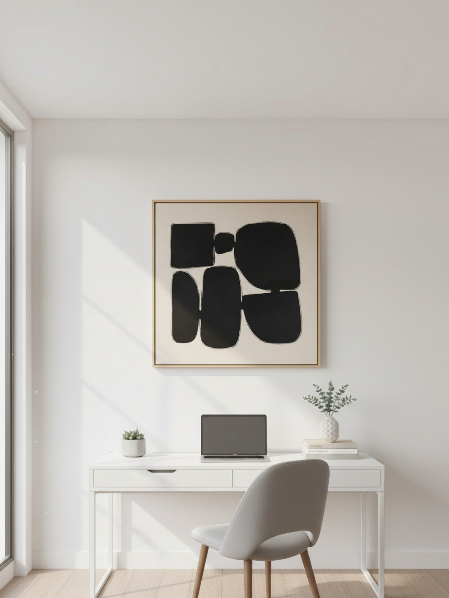 Cadre décoratif TOCO Meubles Pillars II avec art abstrait noir sur fond beige, suspendu au-dessus d'un bureau blanc.