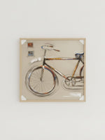 Cadre décoratif TOCO Meubles illustrant un vélo stylisé avec des traits artistiques sur fond beige dans un cadre en bois