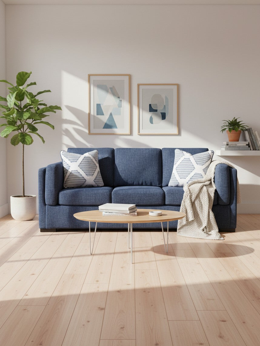 Canapé bleu marine TOCO Meubles avec coussins à motifs dans un salon lumineux au style scandinave