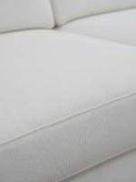 Gros plan sur le revêtement en chenille blanc du canapé Eira de TOCO Meubles, montrant la texture douce et détaillée.
