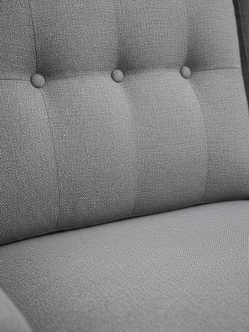 Gros plan sur le revêtement en tissu gris texturé avec boutons décoratifs du canapé sectionnel TOCO Meubles Malo