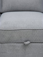 Gros plan sur le tissu gris texturé du canapé-lit Amani de TOCO Meubles avec sa languette de déploiement