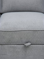 Gros plan sur le tissu gris texturé du canapé-lit Amani de TOCO Meubles avec sa languette de déploiement