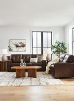TOCO Meubles Canapé-lit Sacha marron en cuir capitonné, 3 places, avec accoudoirs carrés et coussins décoratifs.