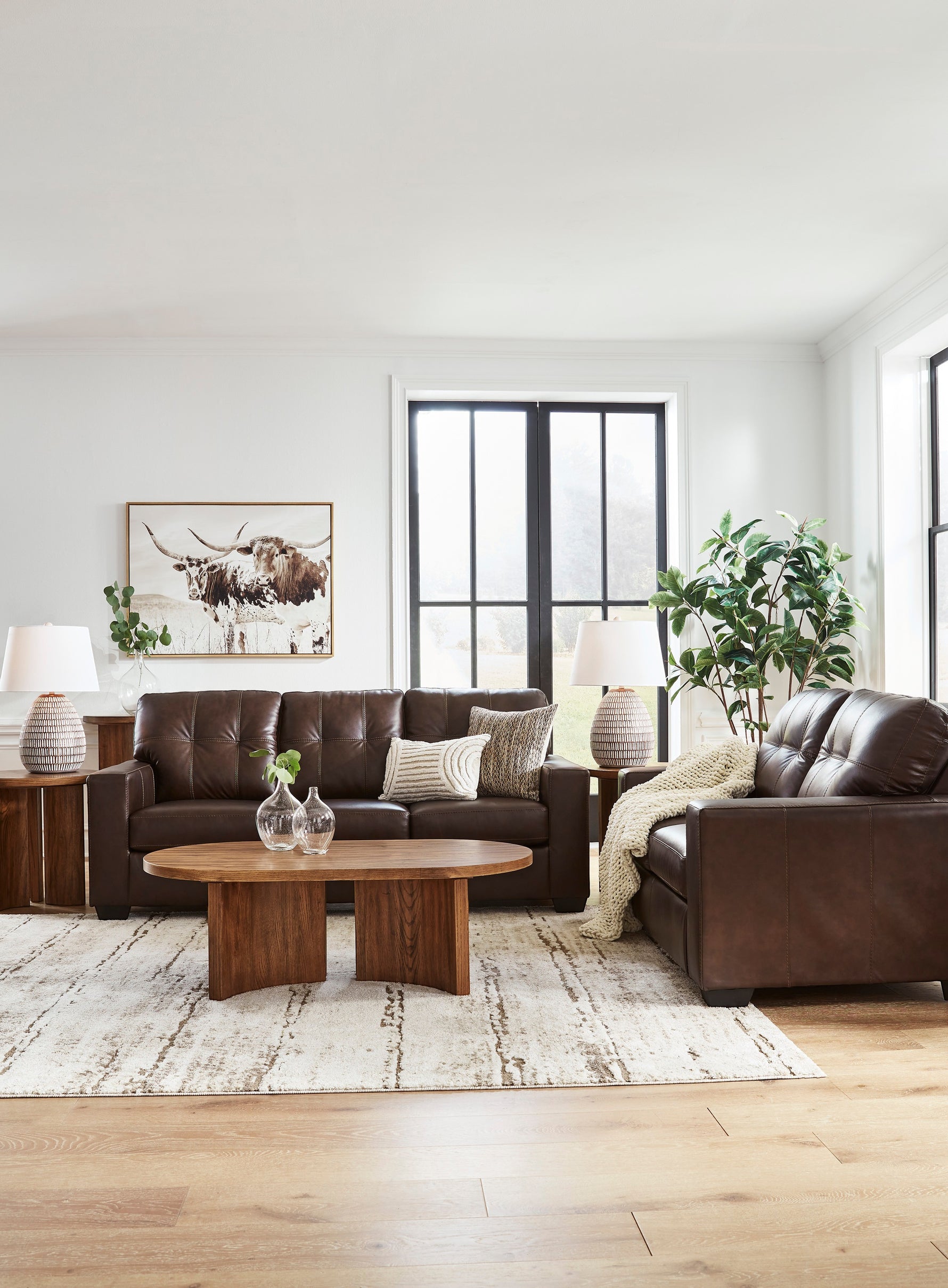 TOCO Meubles Canapé-lit Sacha marron en cuir capitonné, 3 places, avec accoudoirs carrés et coussins décoratifs.