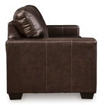 Canapé-lit Sacha marron foncé en cuir et aspect-cuir avec surpiqûres contrastantes et coussin assorti. TOCO Meubles.