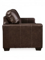 Canapé-lit Sacha marron foncé en cuir et aspect-cuir avec surpiqûres contrastantes et coussin assorti. TOCO Meubles.
