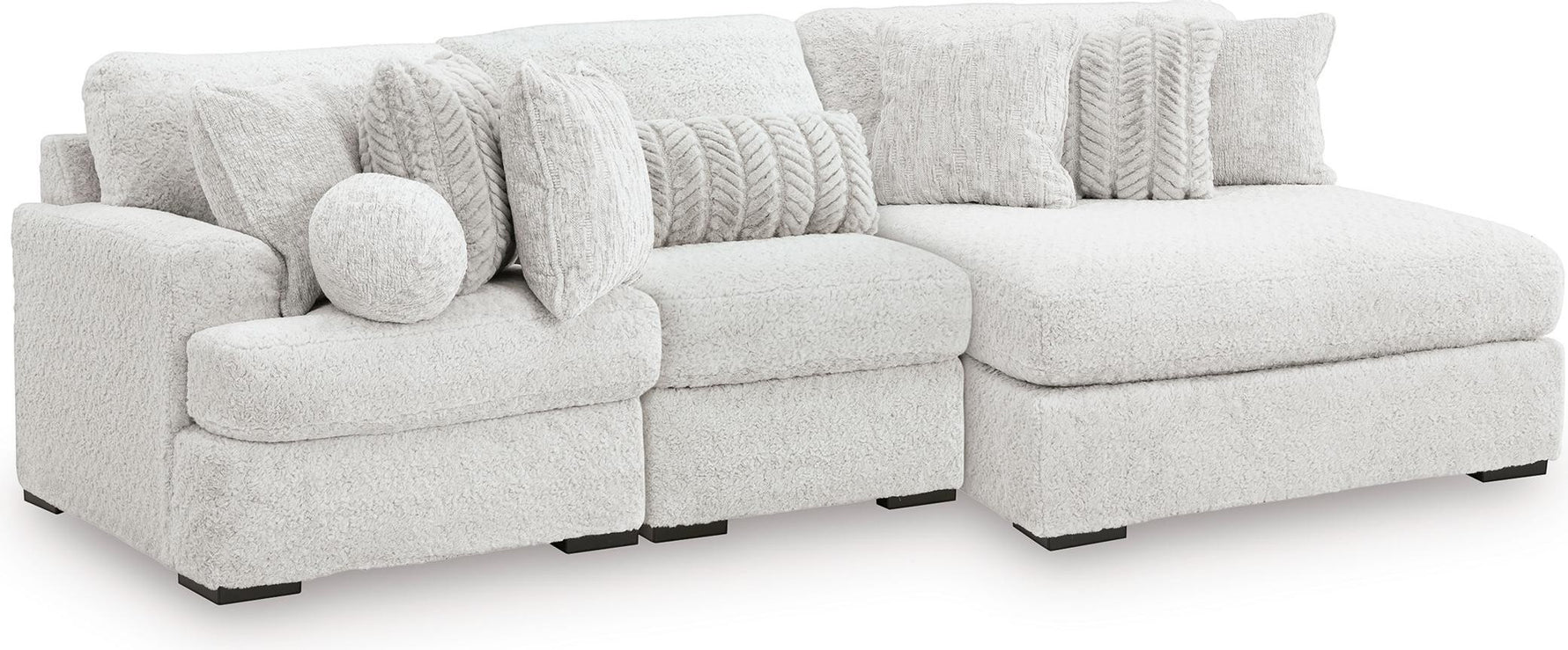 TOCO Meubles Canapé modulaire blanc en tissu texturé avec chaise longue et coussins décoratifs.