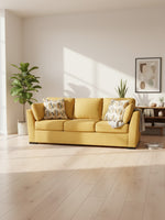Canapé TOCO Meubles Owick jaune tournesol avec coussins à motifs dans un salon lumineux et moderne