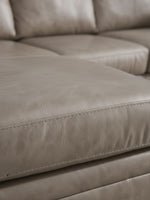 Gros plan sur le revêtement en cuir beige du canapé sectionnel Amuleto de TOCO Meubles avec coutures détaillées