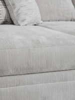 Gros plan sur le tissu texturé gris clair du canapé sectionnel Gaby de TOCO Meubles avec coussins décoratifs