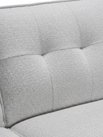 Gros plan sur le revêtement en tissu gris texturé et capitonné du canapé sectionnel Célestin de TOCO Meubles