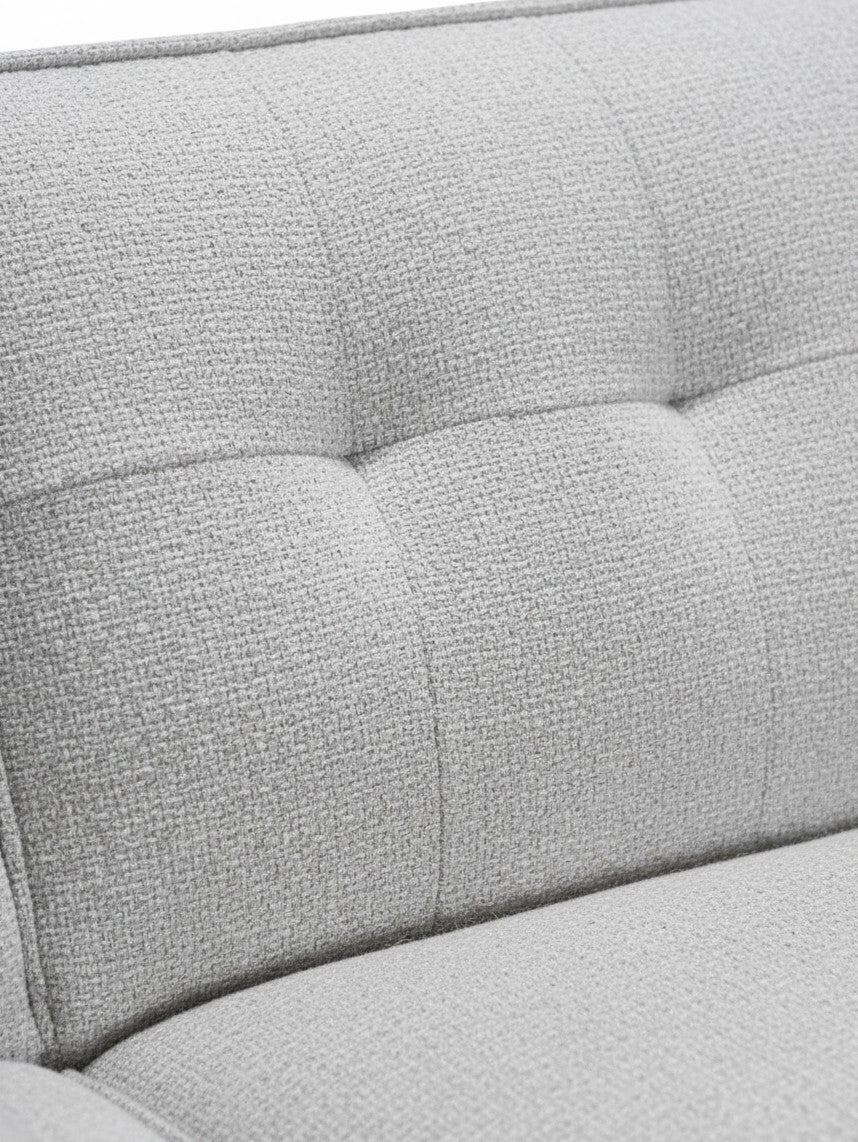 Gros plan sur le revêtement en tissu gris texturé et capitonné du canapé sectionnel Célestin de TOCO Meubles