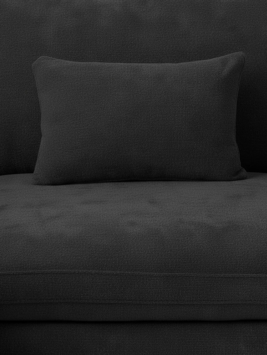 Gros plan sur le coussin et l'assise du canapé sectionnel noir en chenille et lin de TOCO Meubles