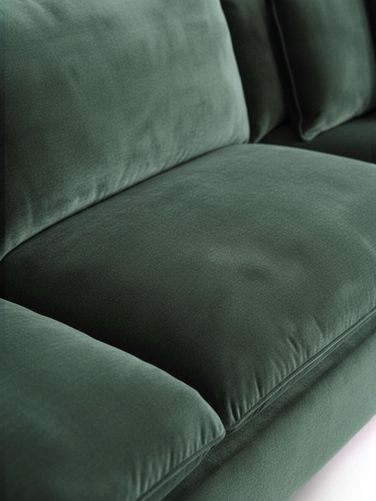 Gros plan sur le canapé sectionnel Elliott de TOCO Meubles en velours vert profond, texture douce et confortable.