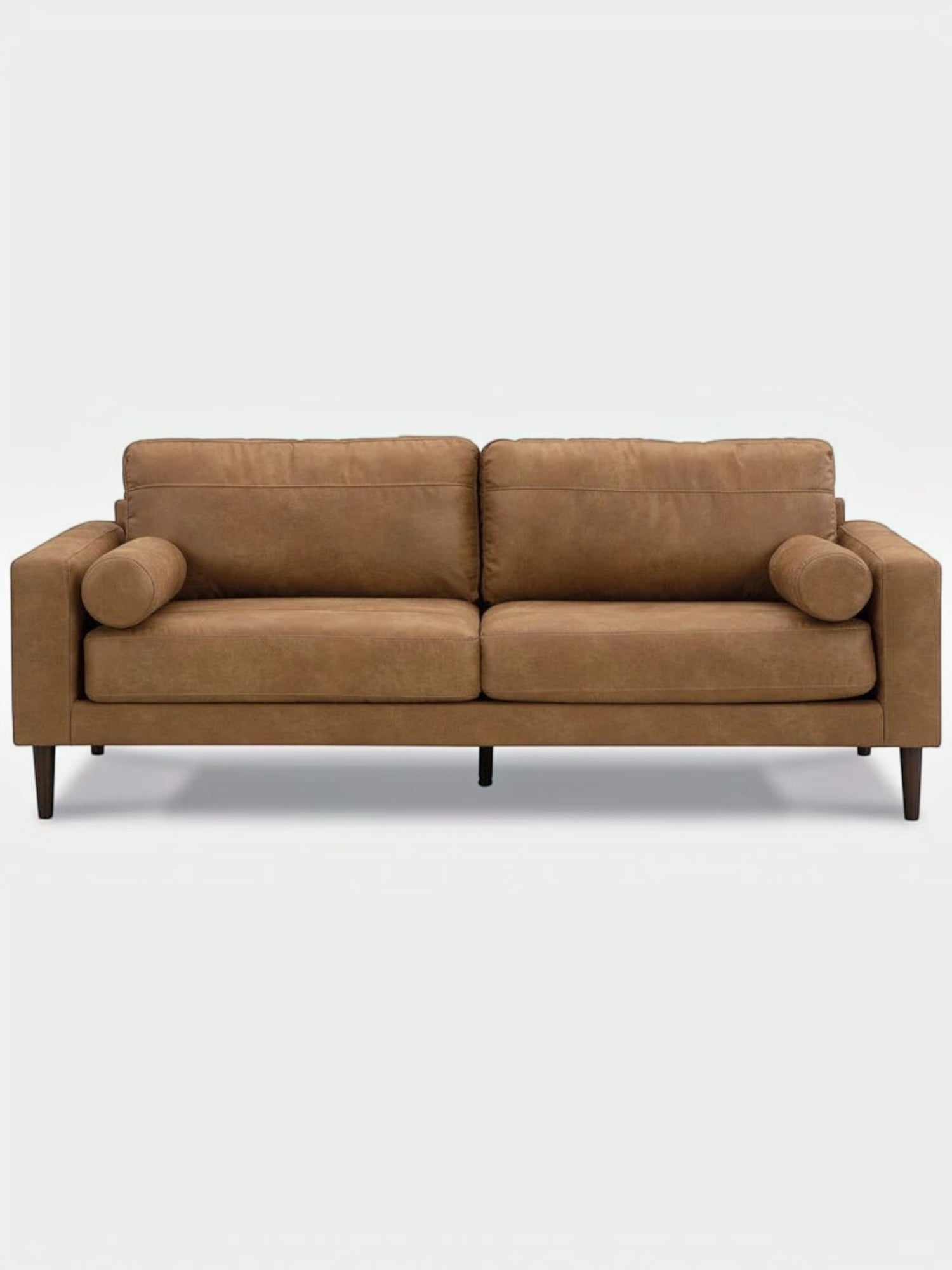 Canapé TOCO Meubles Telora en cuir caramel avec coussins cylindriques et pieds en bois foncé, vue de face