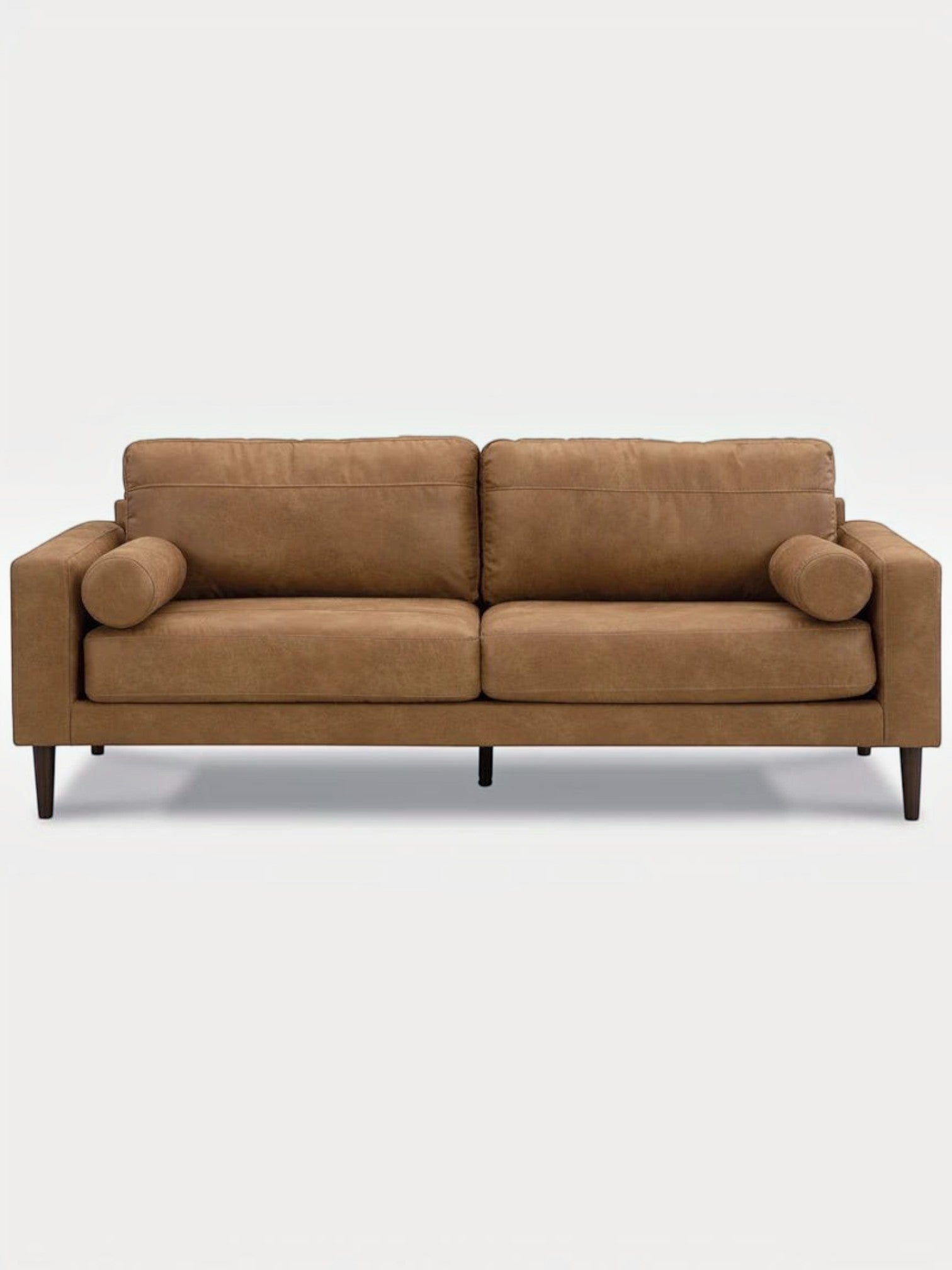 Canapé TOCO Meubles Telora en cuir caramel avec coussins cylindriques et pieds en bois foncé, vue de face