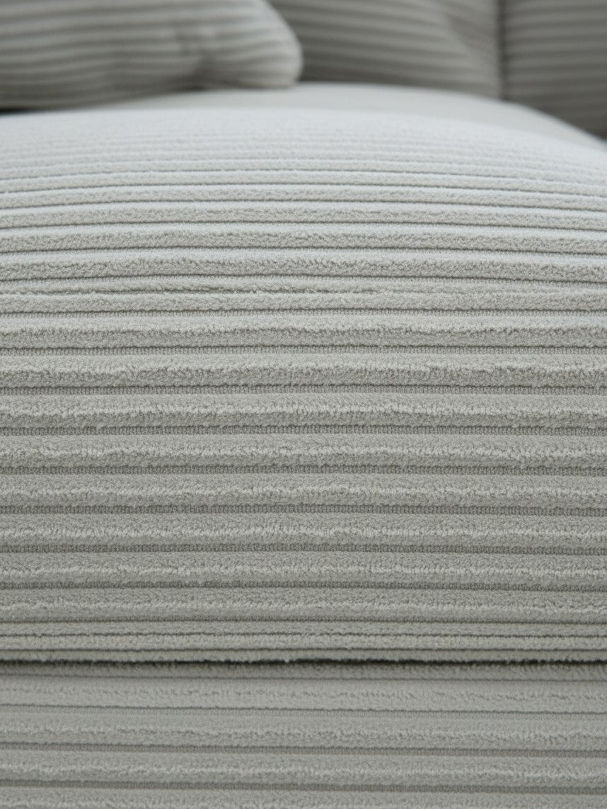 Gros plan sur le tissu en velours côtelé gris clair de la causeuse Aldo de TOCO Meubles