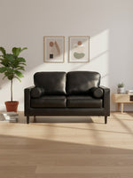 Causeuse Bryce TOCO Meubles en cuir noir avec coussins cylindriques dans un salon moderne et lumineux