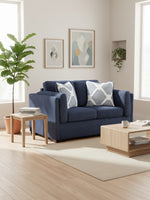 Causeuse Evan bleu marine de TOCO Meubles avec coussins décoratifs à motifs géométriques dans un salon moderne