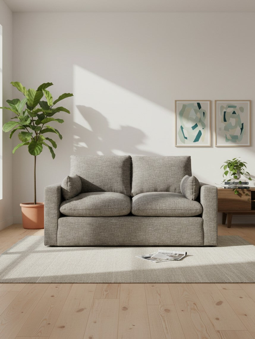 Causeuse Faro TOCO Meubles en tissu gris granite dans un salon lumineux avec plante et cadres muraux