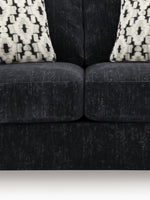 Causeuse Mistral TOCO Meubles en tissu noir texturé avec deux coussins décoratifs à motifs géométriques blancs et noirs