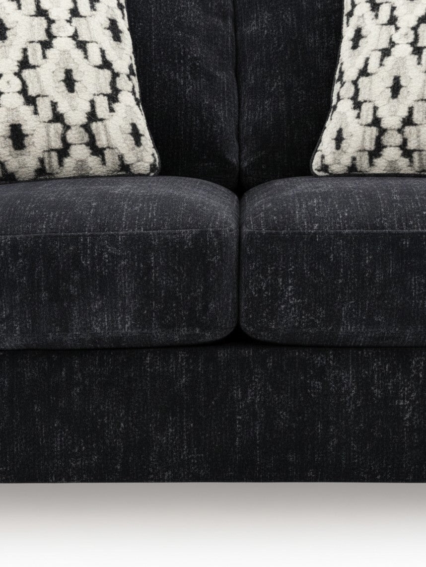 Causeuse Mistral TOCO Meubles en tissu noir texturé avec deux coussins décoratifs à motifs géométriques blancs et noirs