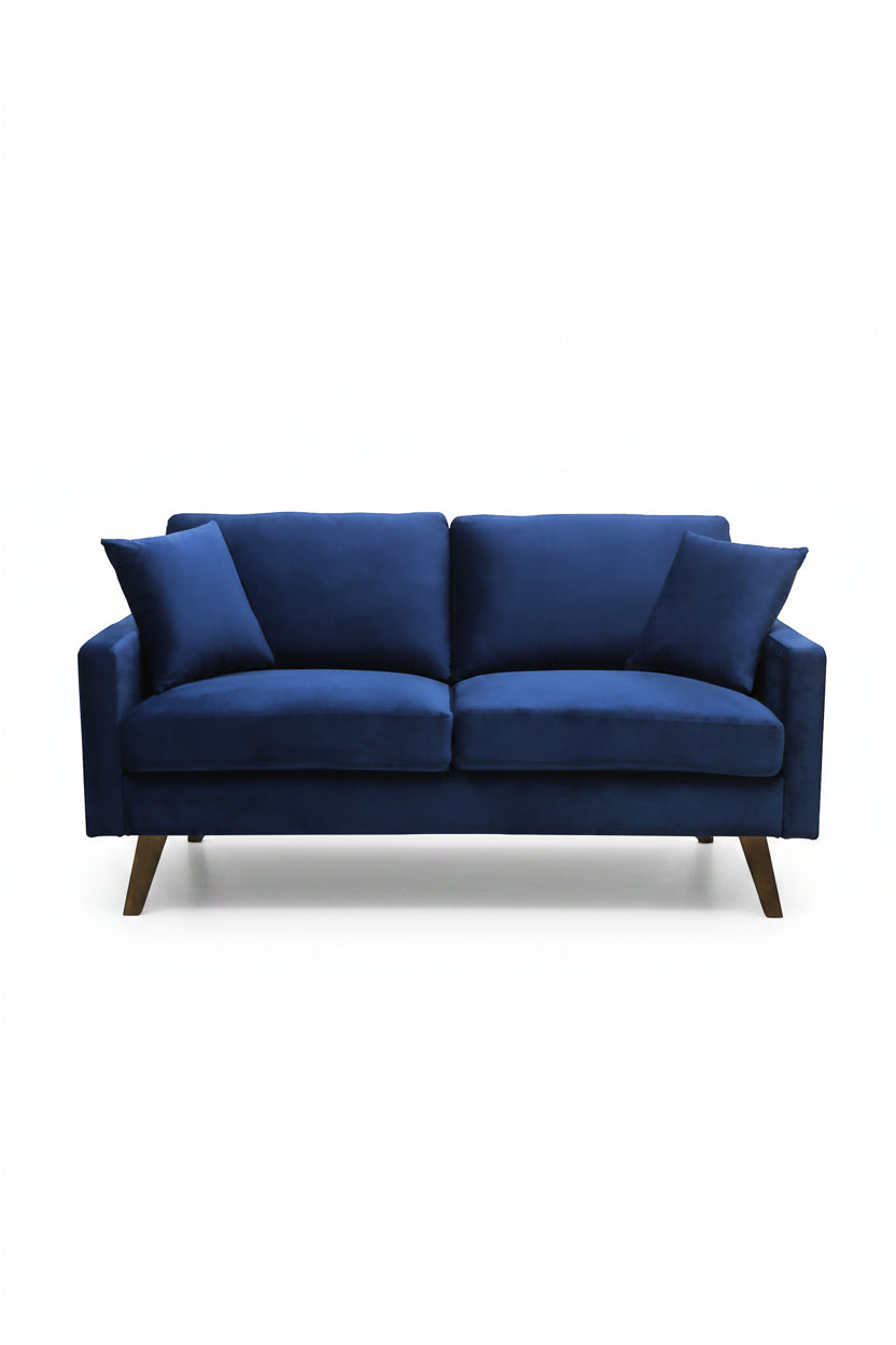 Causeuse Royal bleue marine en velours de TOCO Meubles, avec coussins assortis et pieds en bois obliques.