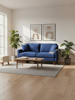 Causeuse Royal TOCO Meubles bleu profond en tissu avec pieds en bois dans un salon moderne et lumineux