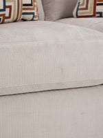 Gros plan sur le tissu en velours côtelé beige de la causeuse Toscana de TOCO Meubles avec coussins à motifs