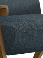 Gros plan sur le tissu bouclette bleu marine et la structure en bois du fauteuil d'appoint Carl de TOCO Meubles