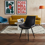 Chaise de salle à manger Belair en similicuir noir capitonné avec surpiqûres décoratives et pieds noirs par TOCO Meubles.