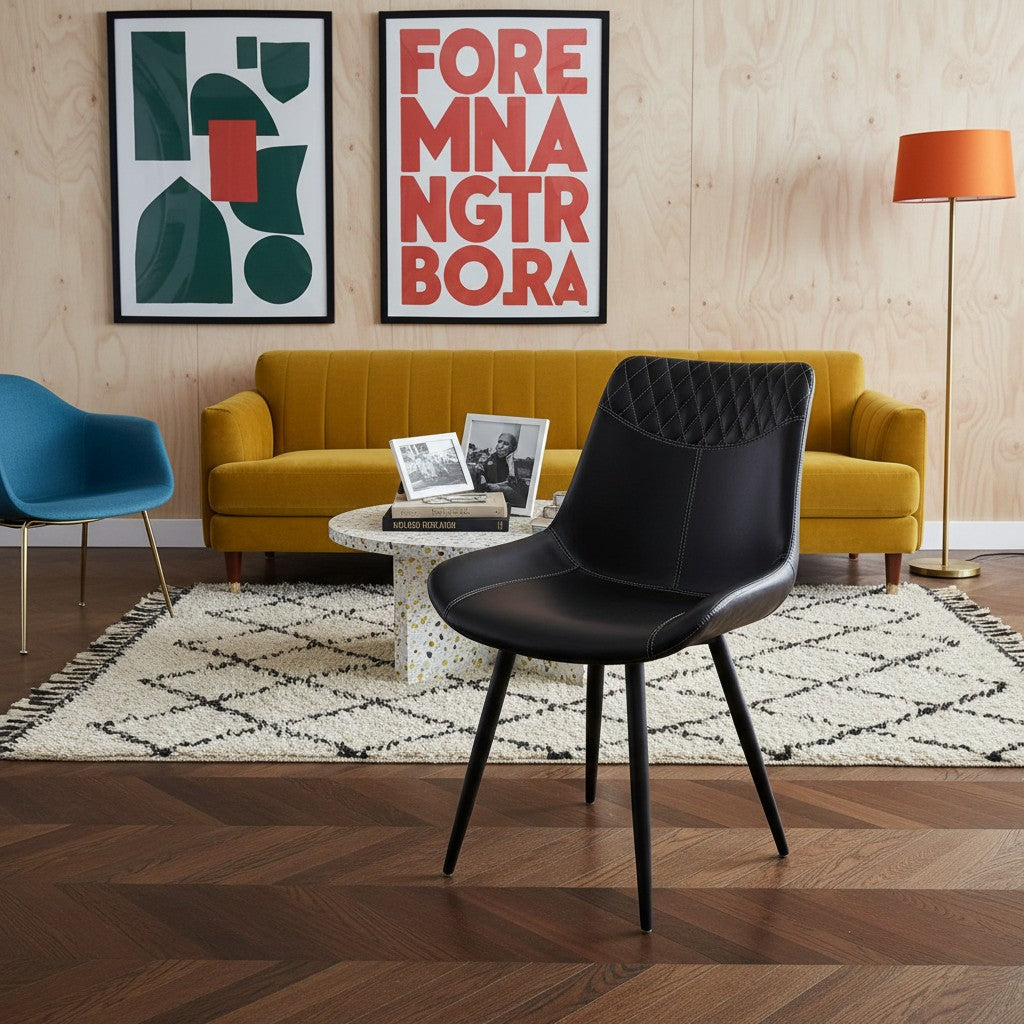 Chaise de salle à manger Belair en similicuir noir capitonné avec surpiqûres décoratives et pieds noirs par TOCO Meubles.