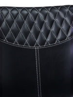 Gros plan sur le dossier en similicuir noir de la chaise TOCO Meubles Belair avec capitonnage diamant et surpiqûres