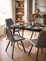 Chaise de cuisine Cynthia TOCO Meubles grise en similicuir avec pieds en métal noir dans une salle à manger moderne