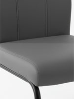 Gros plan sur le revêtement en similicuir gris de la chaise de cuisine Xena par TOCO Meubles avec coutures apparentes