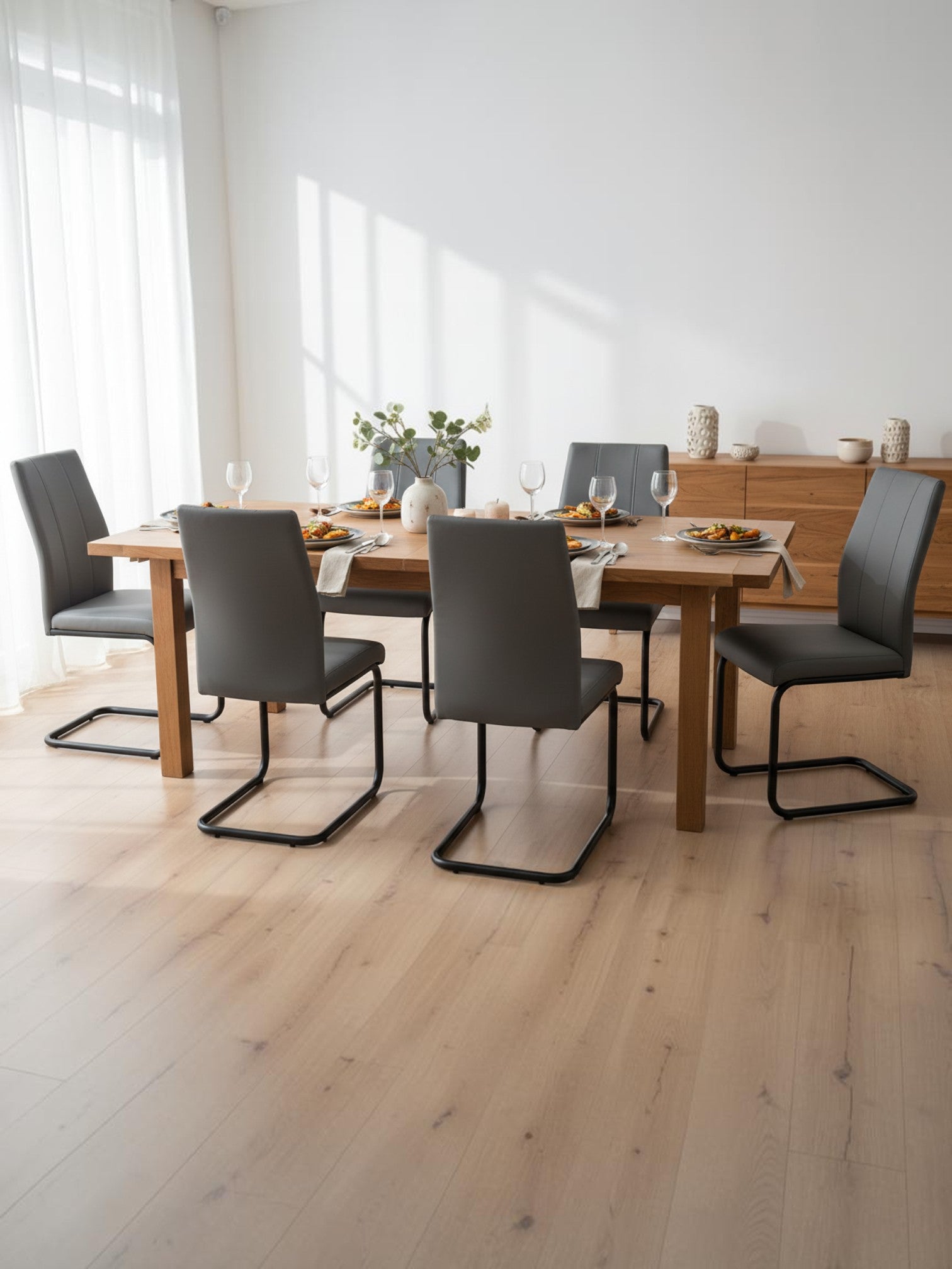 Chaise de cuisine Xena par TOCO Meubles en similicuir gris avec structure en métal noir dans une salle à manger