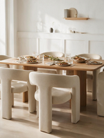 Chaise de salle à manger Emara par TOCO Meubles en chenille beige avec design moderne à trois pieds autour d'une table