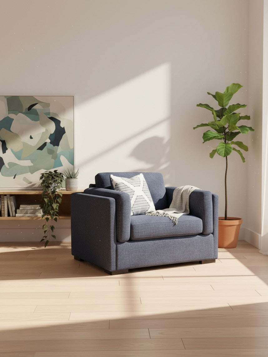 Chaise et demi TOCO Meubles Evan en tissu bleu marine avec coussin décoratif et jeté dans un salon ensoleillé