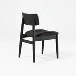 Chaise Transformer TOCO Meubles en hickory fumé, assise rembourrée noire, design moderne et ergonomique.