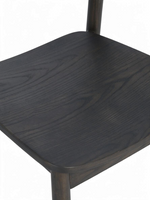 Gros plan sur l'assise en bois massif mocha de la chaise de salle à manger Jona par TOCO Meubles avec grain visible
