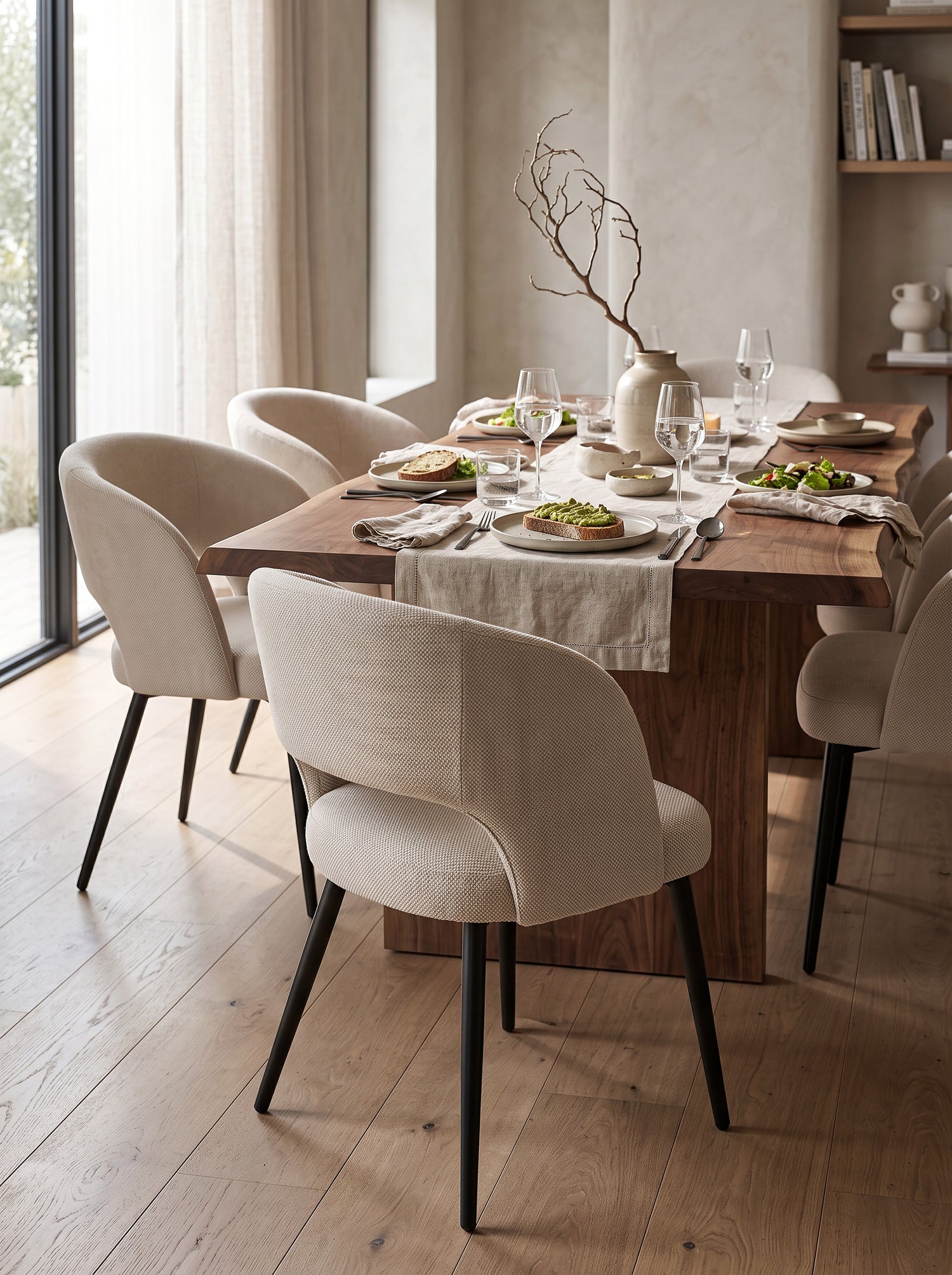 Chaise de cuisine Kamilia TOCO Meubles beige avec dossier arrondi et pieds noirs dans une salle à manger moderne